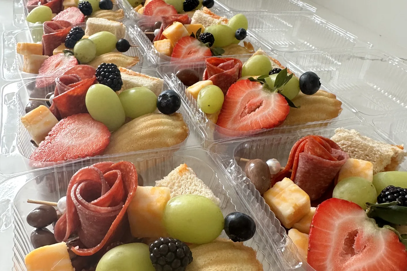 Vasitos individuales de charcutería con rosas de salami, queso, frutas y galletas