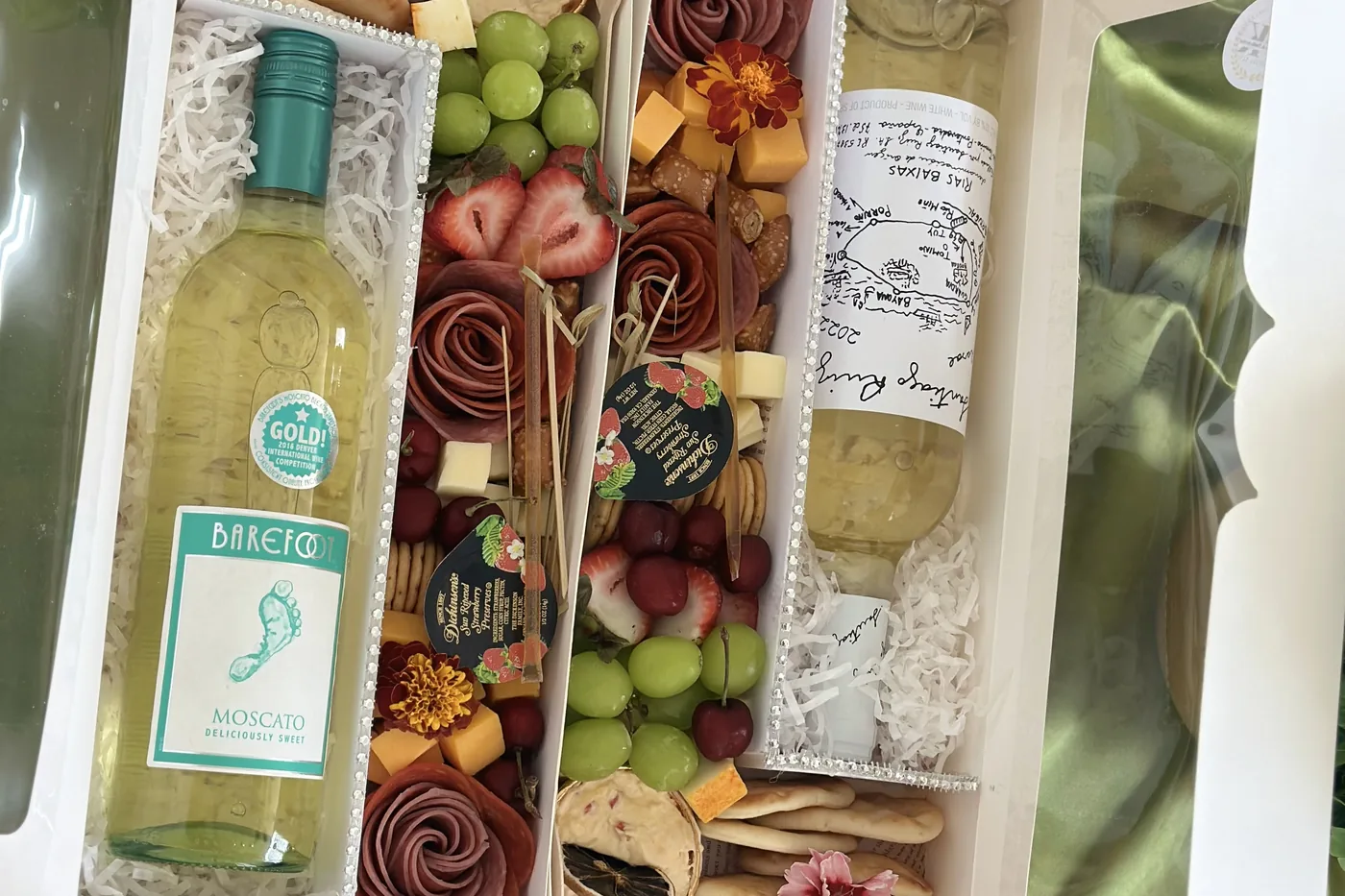 Cajas premium de charcutería acompañadas de botellas de vino